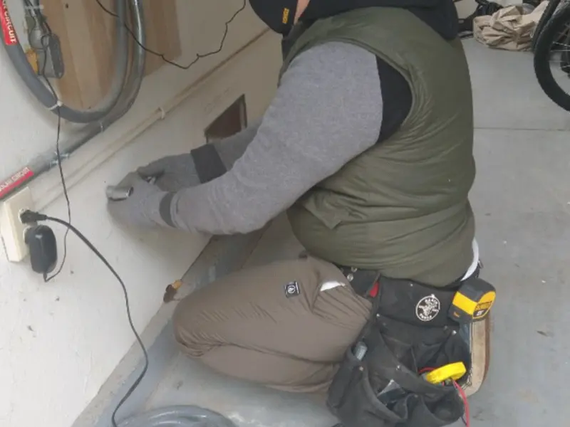 Electrician performing outlet wiring in a Westchase garage